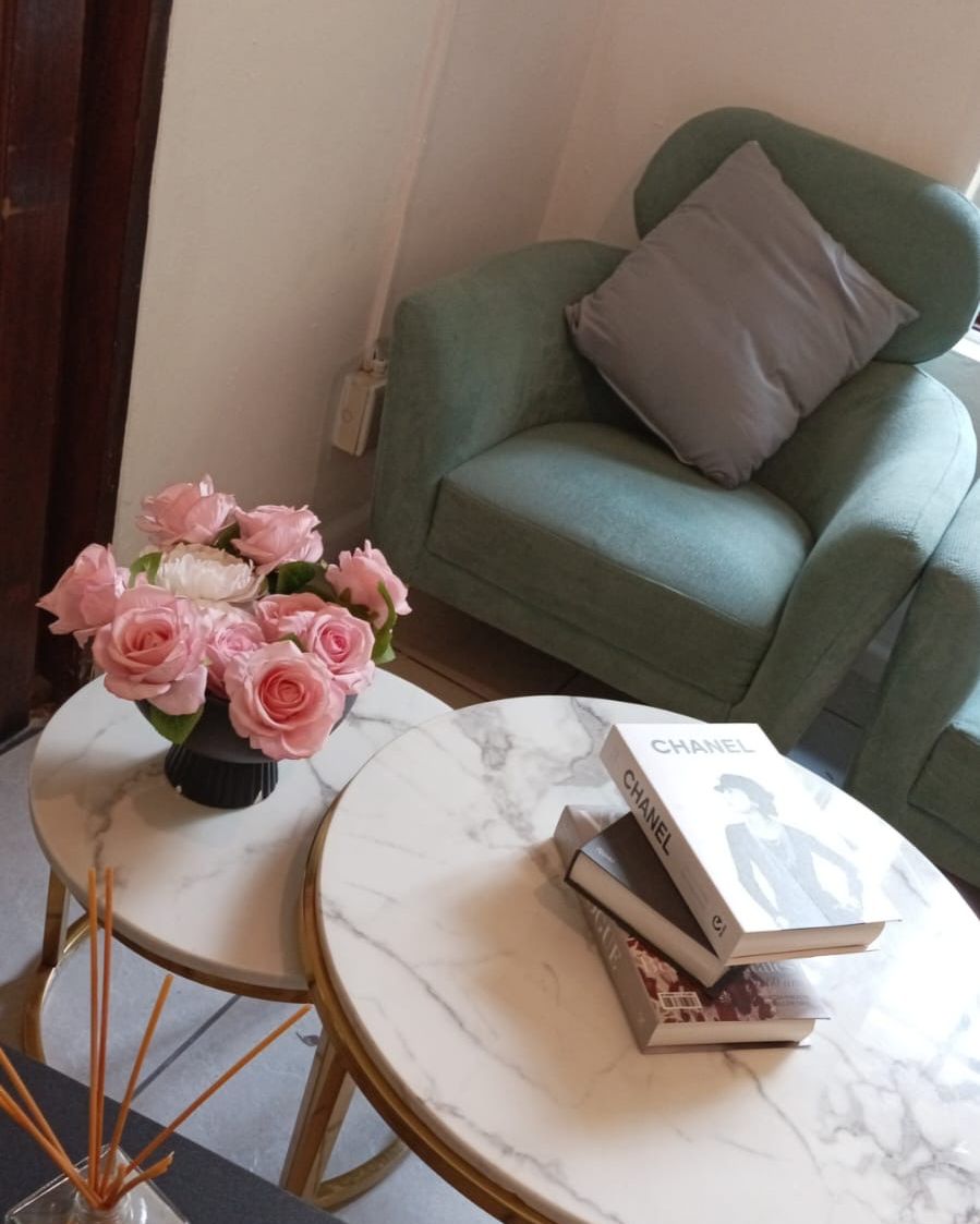 Sage armchair and marble tables in the Beauty Cave lounge