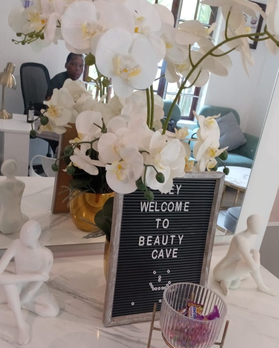 Welcome to Beauty Cave letter board with white orchids